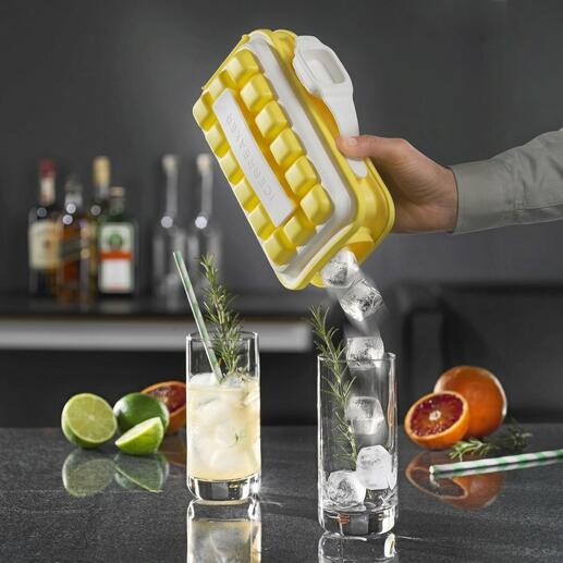 Main tenant un moule à glaçons Ice-Pop, des glaçons tombent dans un verre avec une boisson.