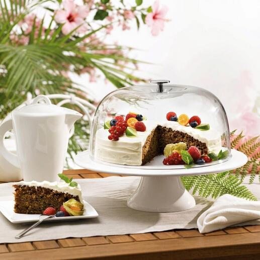 Cloche à gâteau avec un gâteau et des fruits sur une table