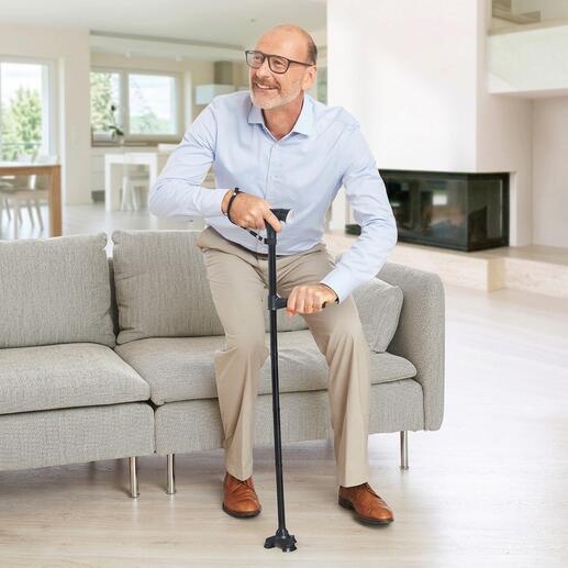Personne assise avec Clever Cane aide à la marche sur le canapé.
