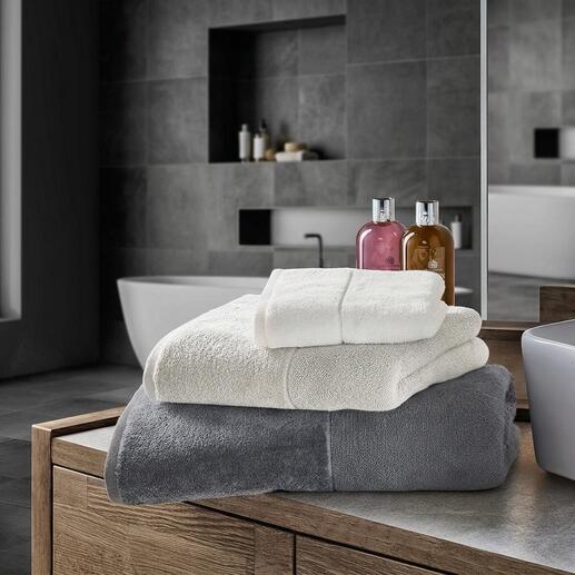 Serviettes de bain claires en blanc et gris sur un meuble de salle de bain