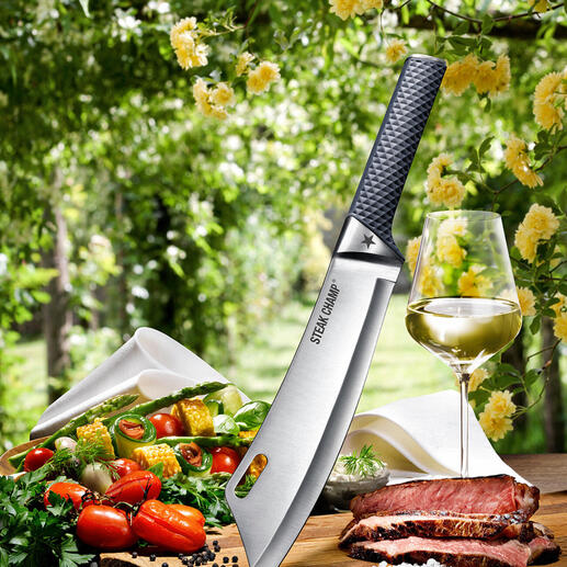 Couteau de cuisine SteakChamp vu du dessus, entouré de légumes et de viande sur une planche à découper.
