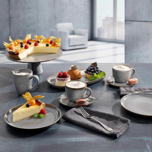 Vaisselle avec différentes assiettes, tasses et gâteaux sur une table.