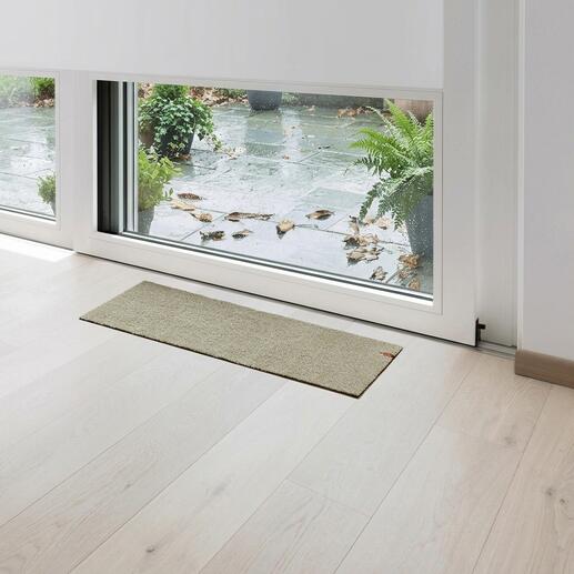 Tapis de porte de terrasse beige devant une porte vitrée.