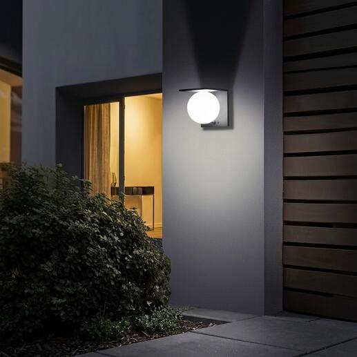 Applique murale solaire avec boule illuminant doucement un mur.