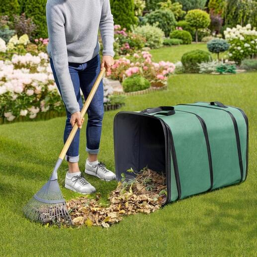 Personne balayant des feuilles dans un collecteur de déchets de jardin carré sur l'herbe