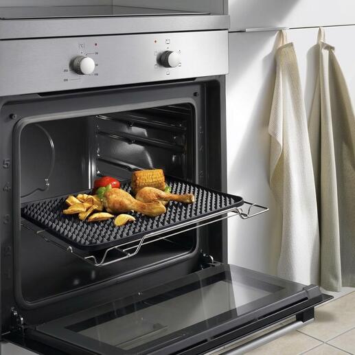 Tapis de cuisson avec des picots dans le four, avec des aliments croustillants comme du poulet et des légumes.