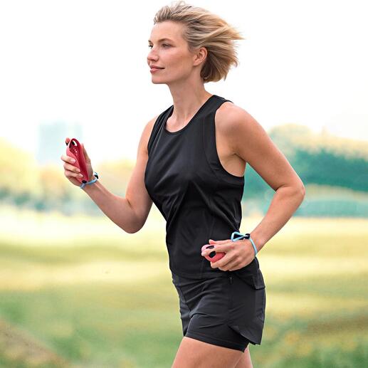 Femme courant à l'extérieur, portant des vêtements de sport et tenant une Laufmaus dans la main.