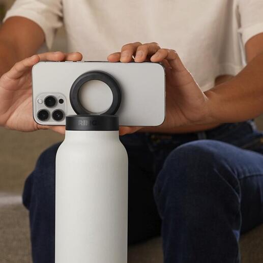 Personne tenant une bouteille 2-en-1 avec un smartphone en équilibre dessus.