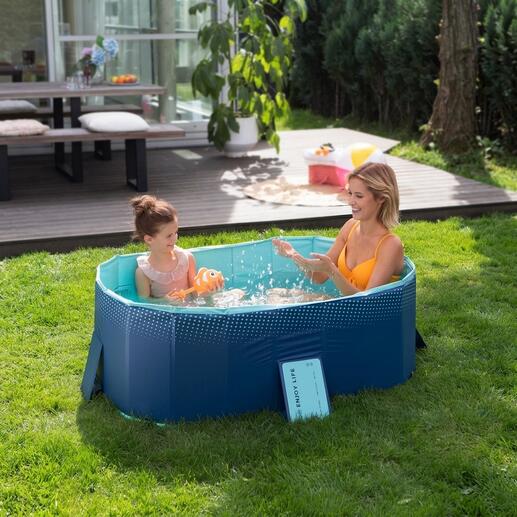 Piscine pliable avec mère et enfant dans l'eau, entourée d'une pelouse verte.
