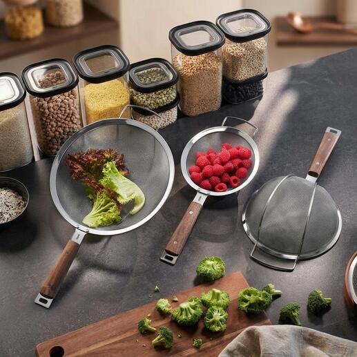 Trois passoires avec des poignées en bois sur une table de cuisine.