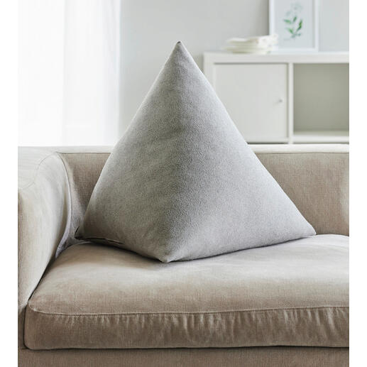 Coussin de dos triangulaire gris clair sur un canapé.