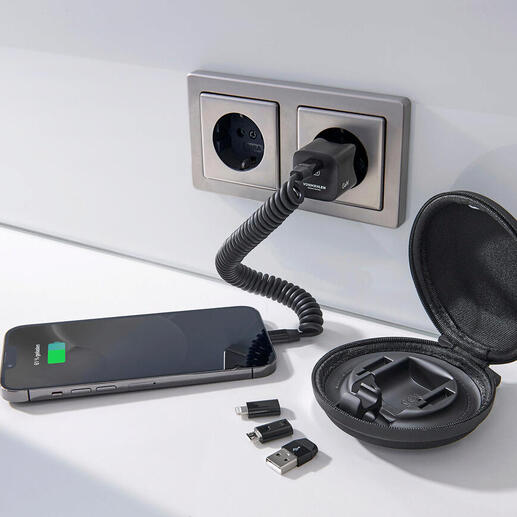 Smartphone, chargeur et accessoires sur une table, entourés d'une prise murale.