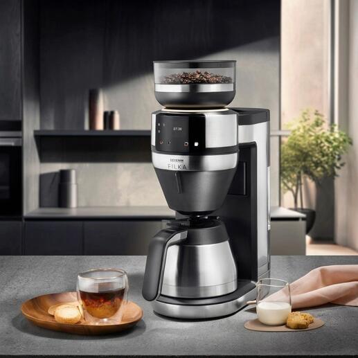 Machine à café filtre FILKA avec une tasse de café et du lait sur une table.