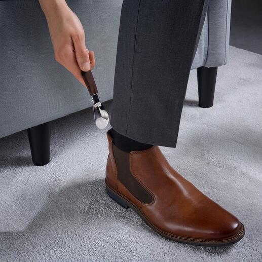 Personne utilisant un embauchoir pliable en cuir de harnais.