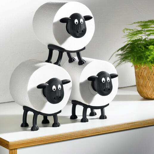 Trois porte-rouleaux de papier toilette en forme de moutons sur une table.