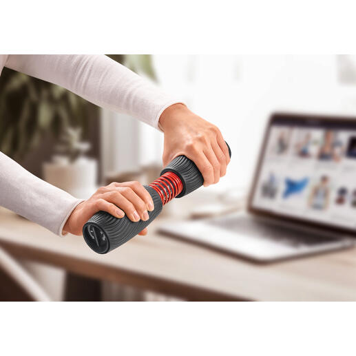 Personne s'entraîne avec un entraîneur de poignet et d'avant-bras sur une table avec un ordinateur portable.