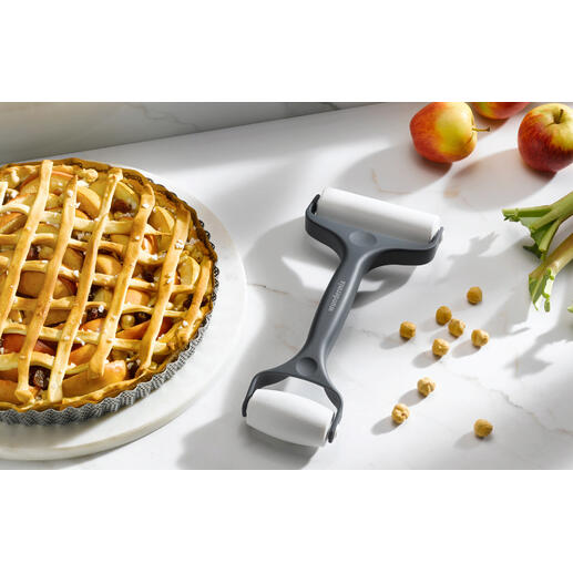 Rouleau à pâtisserie double à côté d'une tarte aux pommes sur une table de cuisine.
