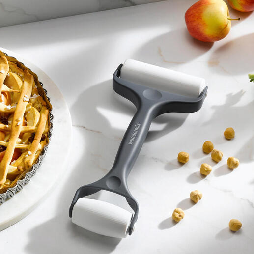 Rouleau à pâtisserie double à côté d'une tarte aux pommes sur une table de cuisine.