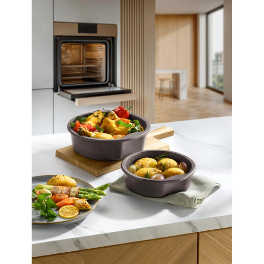 Deux pots celtes avec des légumes et des pommes de terre sur une assiette en bois dans une cuisine moderne.