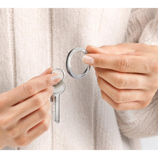 Des mains tenant une clé et un anneau de clé breveté dans un set.
