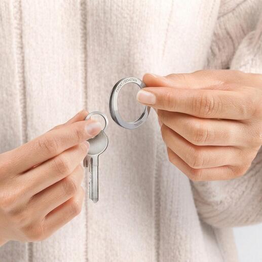Des mains tenant une clé et un anneau de clé breveté dans un set.