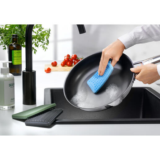 Personne nettoie une poêle avec une éponge en silicone bleue.