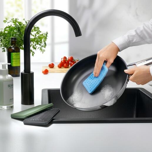 Personne nettoie une poêle avec une éponge en silicone bleue.
