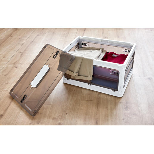 Boîte de rangement ouverte avec des vêtements sur un sol en bois.