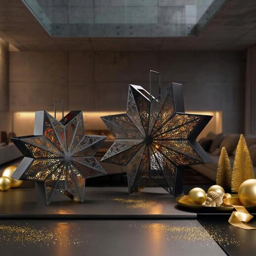 Deux lanternes décoratives en forme d'étoile sur une table avec des boules de Noël dorées.