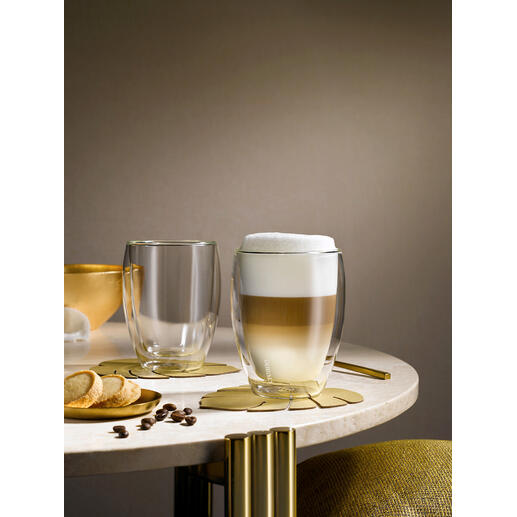 Deux verres thermiques premium sur une table, l'un avec une boisson mousseuse et l'autre vide.