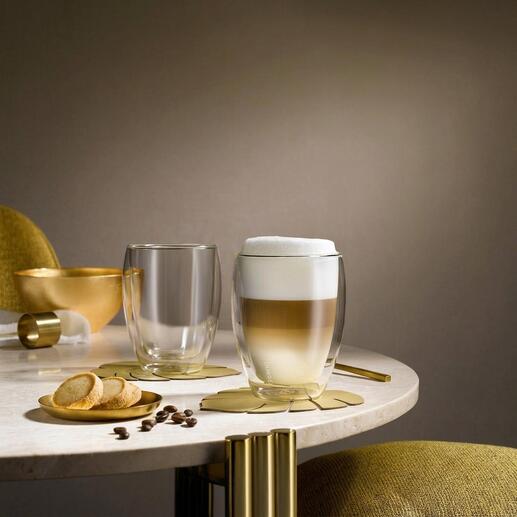 Deux verres thermiques premium sur une table, l'un avec une boisson mousseuse et l'autre vide.