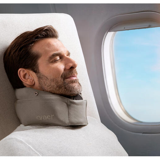 Homme avec un coussin de voyage se détend près de la fenêtre dans l'avion.