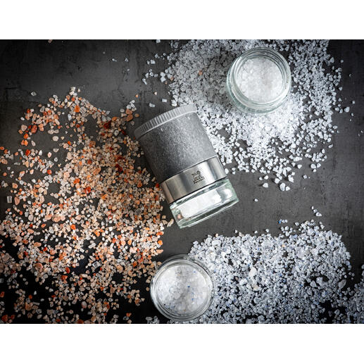 Ensemble de moulins à sel Peugeot Zirkonia sur une table avec du sel