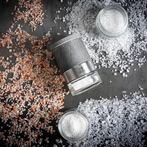 Ensemble de moulins à sel Peugeot Zirkonia sur une table avec du sel