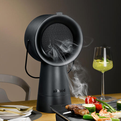 Airhood 2.0 en noir, appareil à griller fumant sur une table avec légumes et viande.