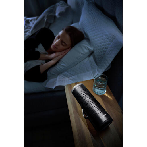 Purificateur d'air mobile 2-en-1 sur une table de nuit à côté d'une personne dormant