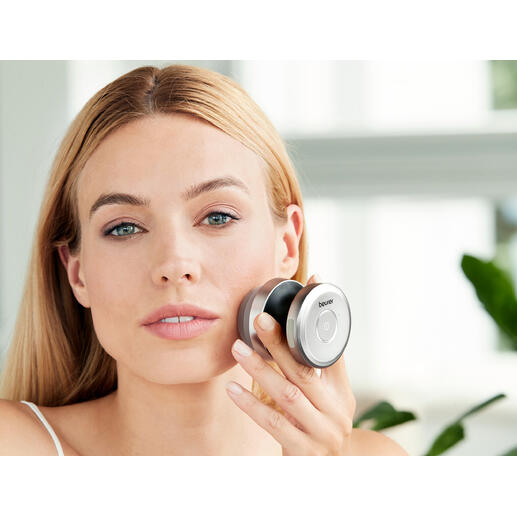 Brosse du visage duale en utilisation, femme tenant la brosse contre son visage.