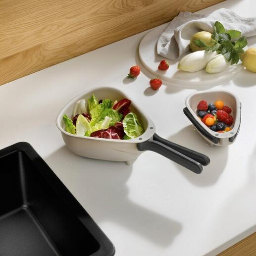 Passoire de cuisine compacte avec des légumes et des fruits frais en arrière-plan.
