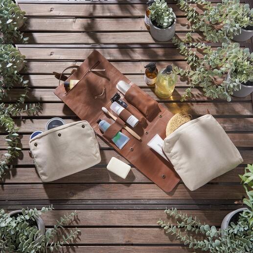 Trousse de toilette en cuir de buffle avec divers produits de soin sur une table.