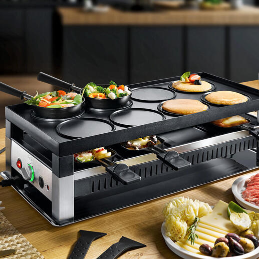 Appareil Solis raclette et fun-cooking 5-en-1 avec légumes et viandes sur la table.