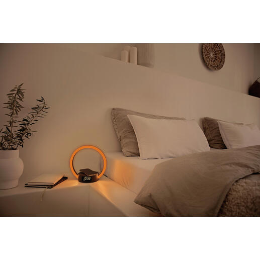 Réveil avec affichage lumineux rond sur une table de chevet.