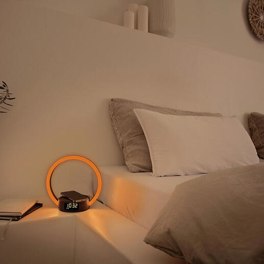 Réveil avec affichage lumineux rond sur une table de chevet.