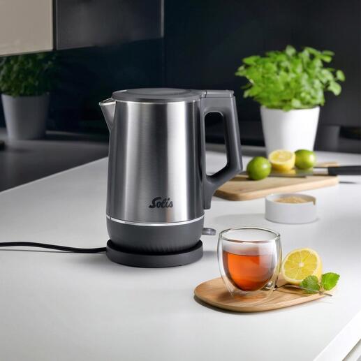 Bouilloire double avec finition en acier inoxydable et thé dans un bol en verre sur la table.