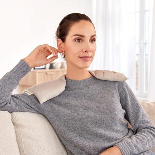 Femme portant un chauffe-épaule assise confortablement sur le canapé
