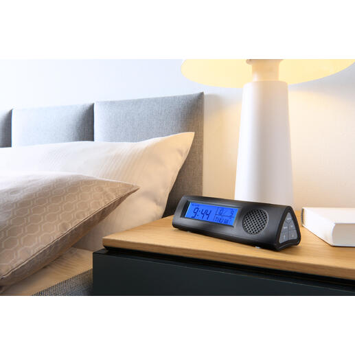 Réveil radio avec lampe de poche LED sur la table de nuit à côté du lit