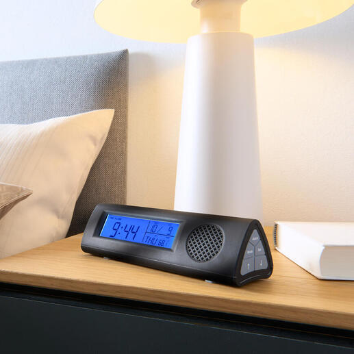 Réveil radio avec lampe de poche LED sur la table de nuit à côté du lit