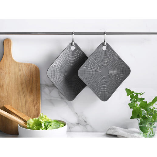 Deux gants de cuisine en silicone gris suspendus à une barre dans une cuisine moderne.