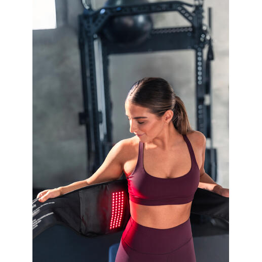 Femme avec une bande de dos 4-en-1 dans une salle de sport.