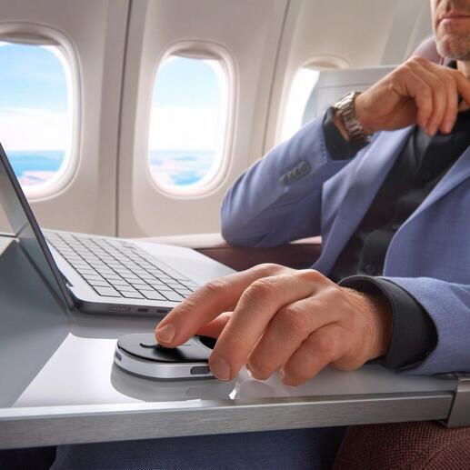 Homme dans un avion utilisant une souris mini sur une table.