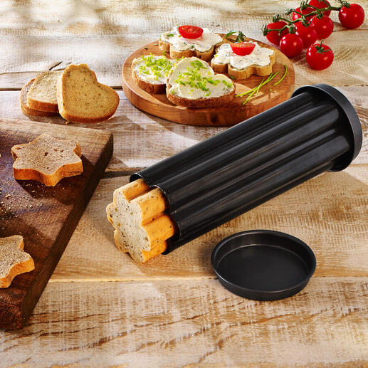 Trois tubes de cuisson pour pain de fête sur une planche en bois avec des formes de pain coupées et garnitures.